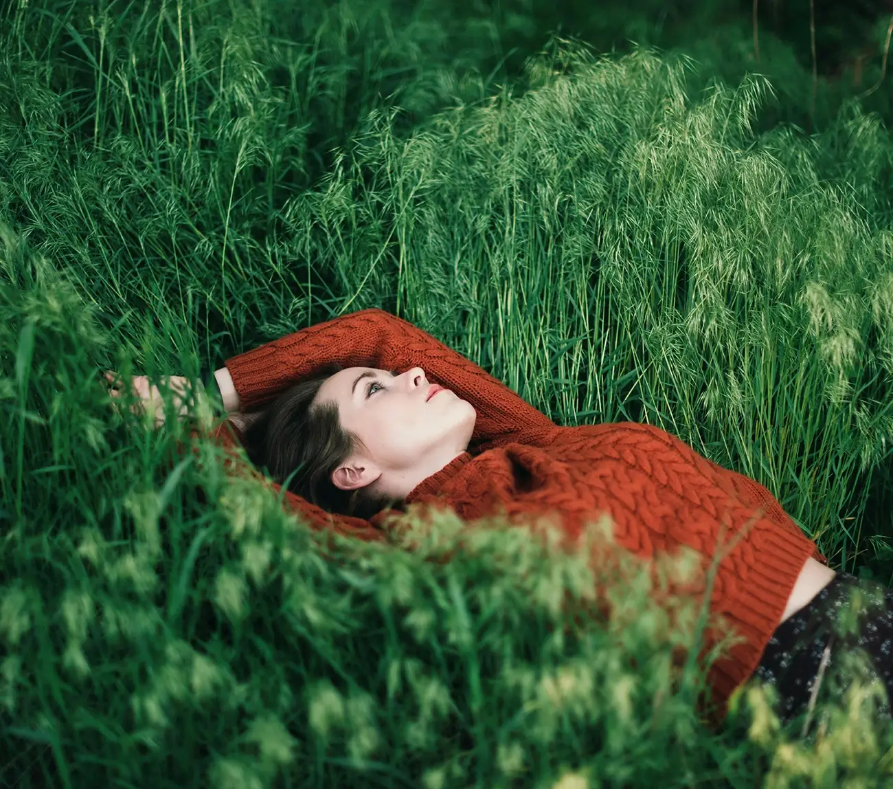 Personne allongée dans l'herbe, en réflexion et à l'écoute de ses besoins profonds